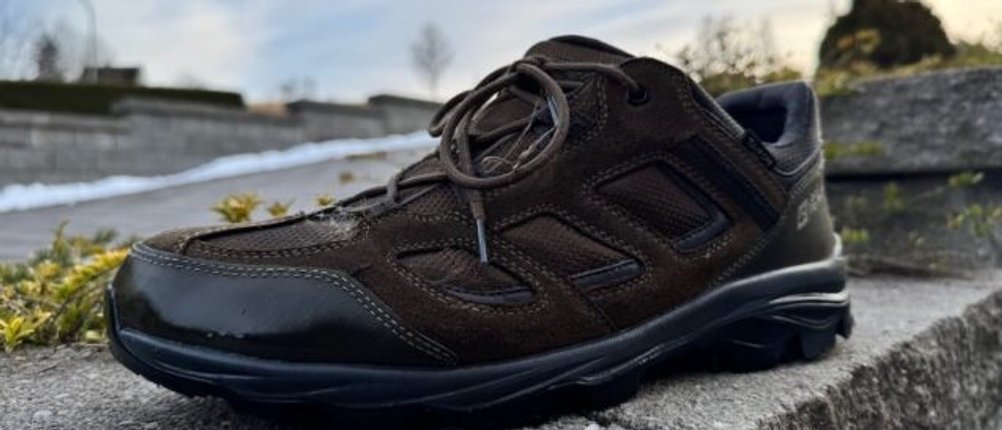 Glänzender Schuh nach dem Imprägnieren auf einer Steinmauer