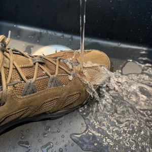Leichter Wasserstrahl auf einem Schuh in einem Waschbecken