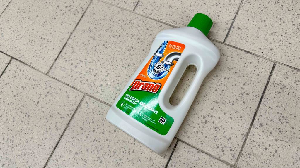 Abflussreiniger-Test: Eine weiße Flasche aus Kunststoff liegt auf dem Boden.