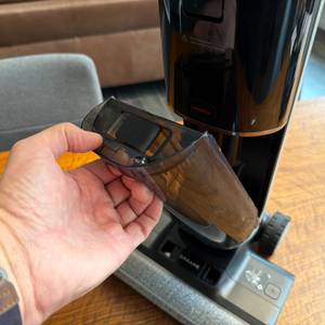 Eine Hand hat einen Behälter vom Dreame H14 Pro entfernt