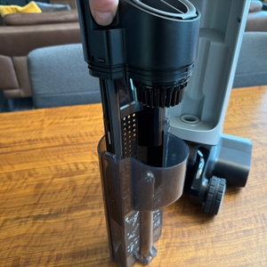 Eine Hand entfernt ein Teil aus dem Behälter vom Dreame H14 Pro