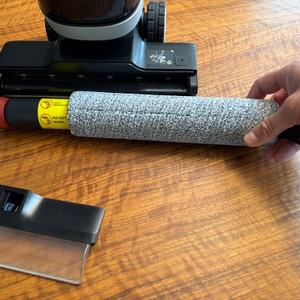 Eine Hand befestigt die Rolle am Dreame H14 Pro