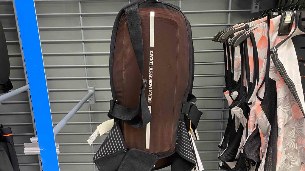 Getesteter Rückenprotektor: braunes Modell hängt an einem Verkaufsstand.