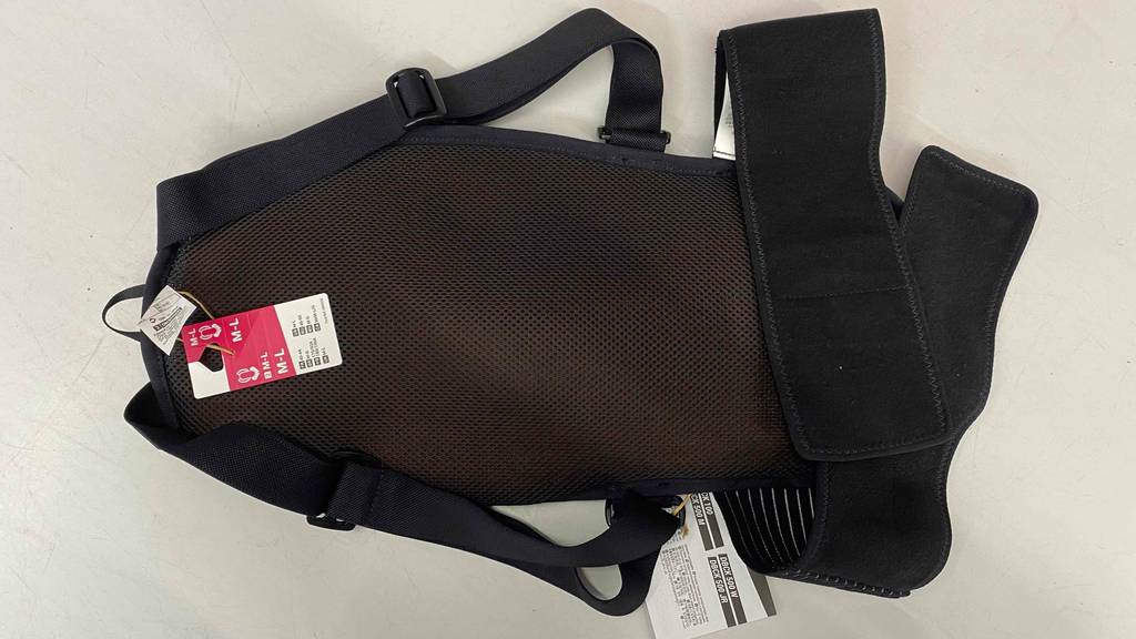 Rückenprotektor-Test: schwarzes Modell liegt mit Blick auf das Gurtsystem auf hellem Untergrund.