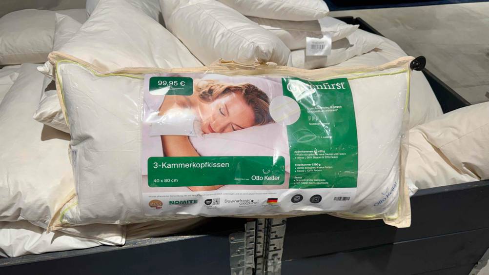 Ein getestetes Dreikammer-Kopfkissen auf mehreren anderen Kissen in einer Box.
