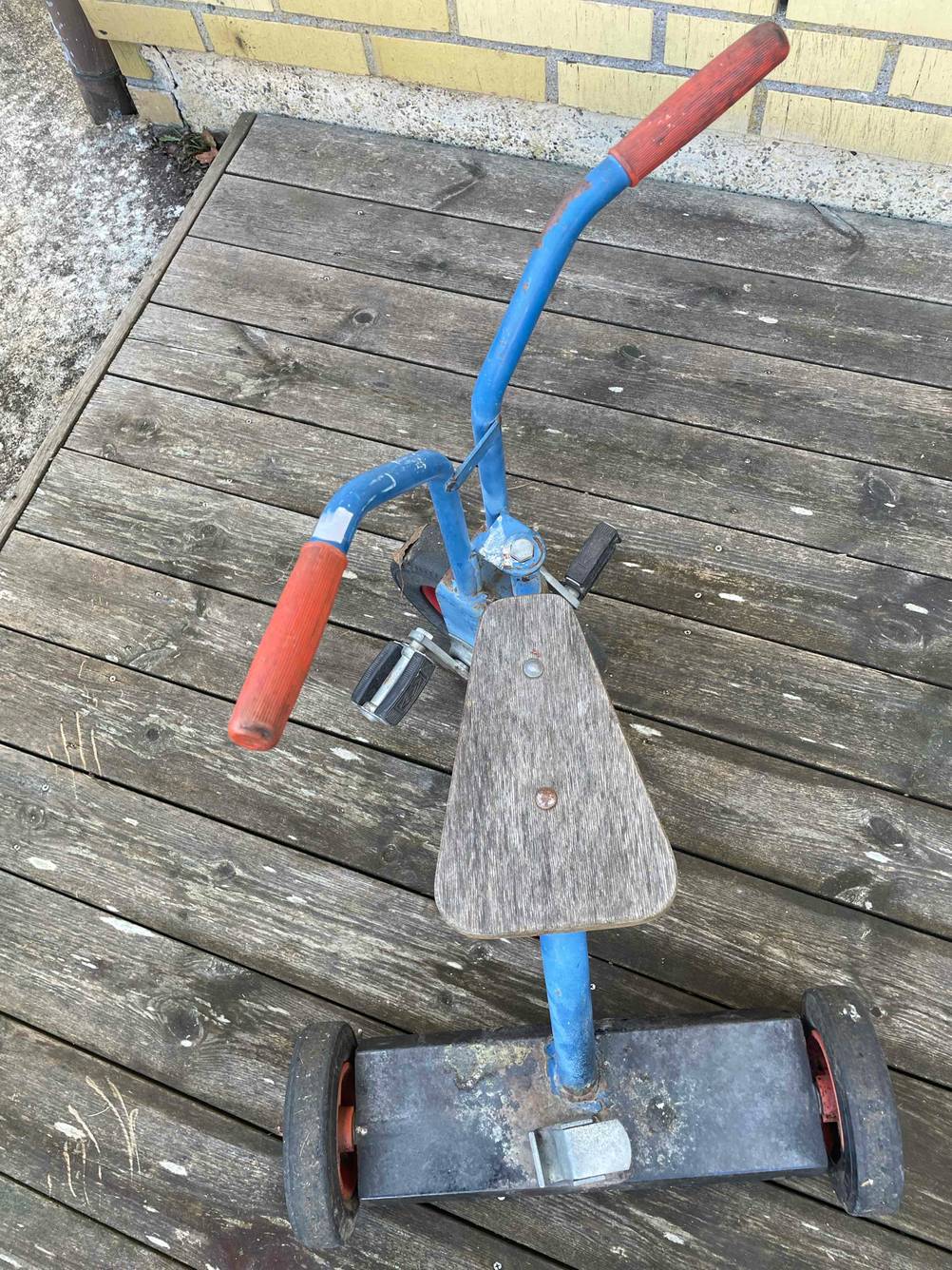 Ein getestetes Dreirad von oben auf einer Holzfläche.