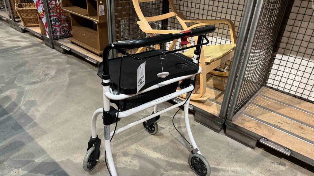 Wohnungsrollator im Test von hinten betrachtet steht in einem Warenlager.