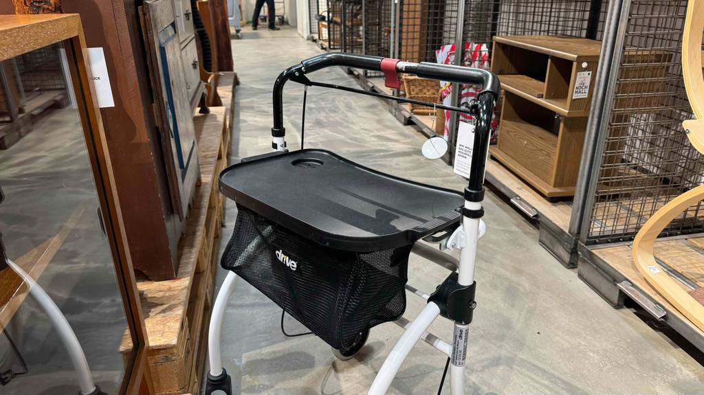 Im Test: Ein Wohnungsrollator mit Fokus auf seine Sitzfläche steht in einem Warenlager.