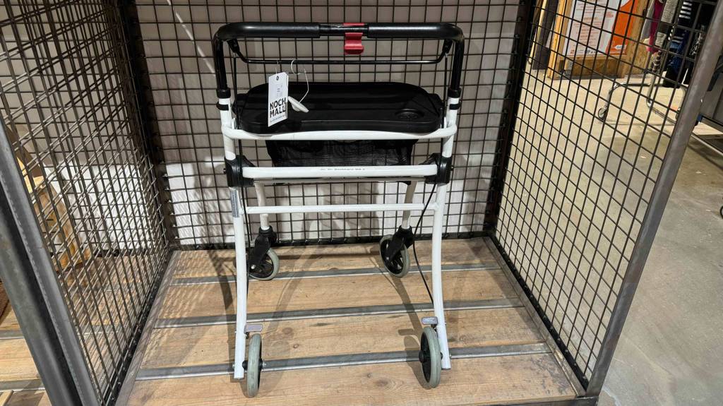 Ein getesteter Wohnungsrollator von hinten betrachtet steht in einer Box innerhalb eines Warenlagers.