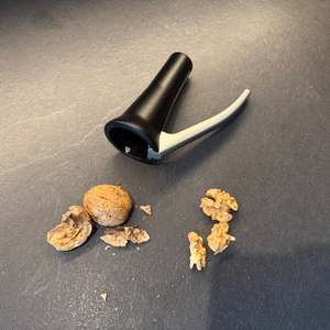 Eine geknackte Walnuss liegt neben dem Drosselmeyer-Nussknacker ‎DR03