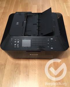 Ein schwarzer, getesteter Canon Drucker steht auf dem Boden.