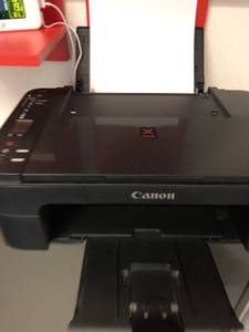 Ein schwarzer Canon Drucker mit eingelegtem Papier im Test.
