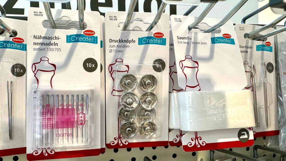 Eine Packung der Druckknöpfe im Test hängt neben anderen Produkten in einem Regal.