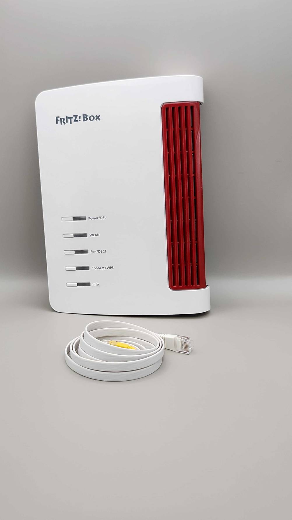 Getestet: Ein DSL-Modem lehnt an einer weißen Wand, davor liegt ein Kabel.
