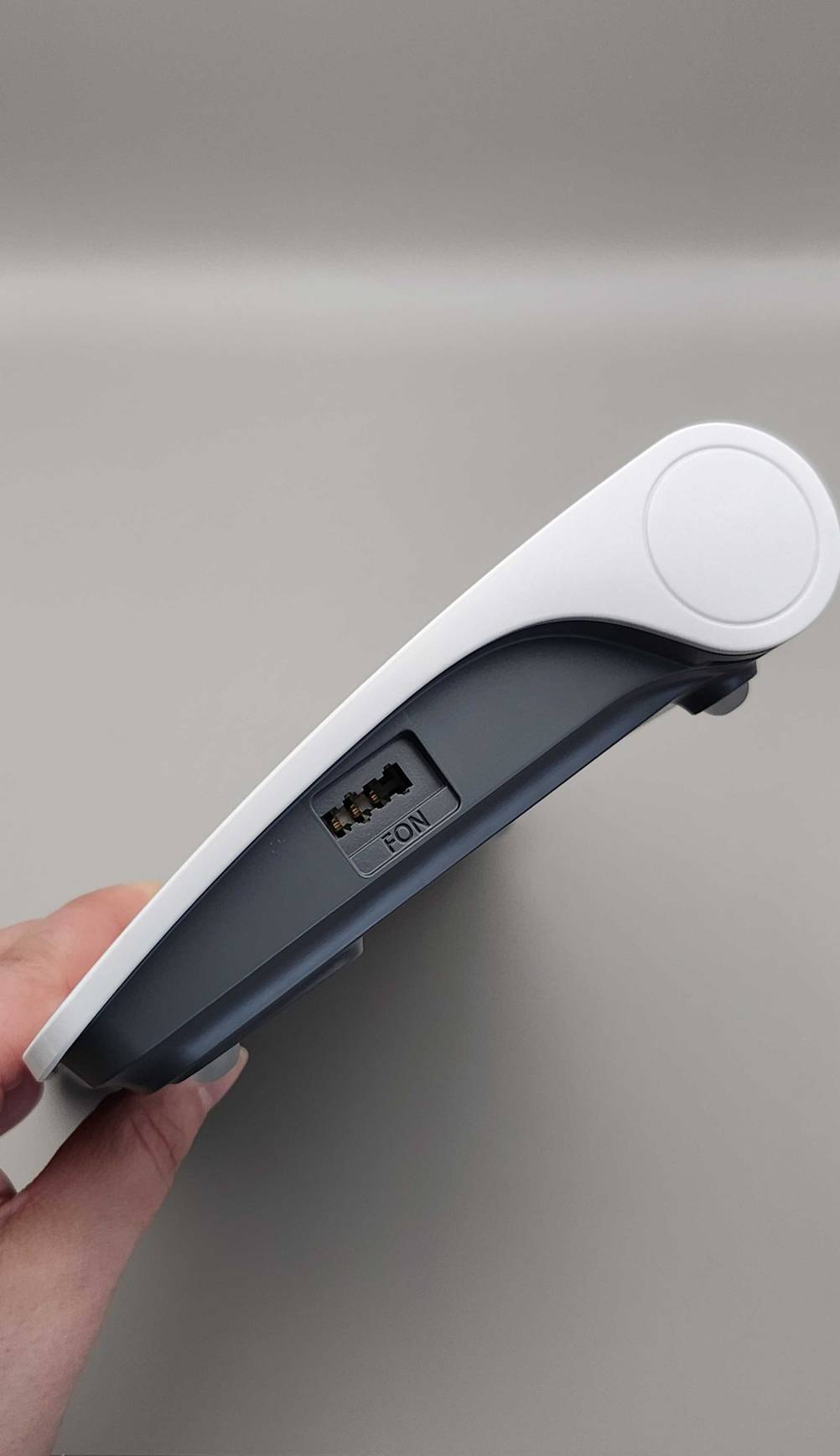 Eine Hand hält ein DSL-Modem im Test seiltlich mit Fon-Anschluss.