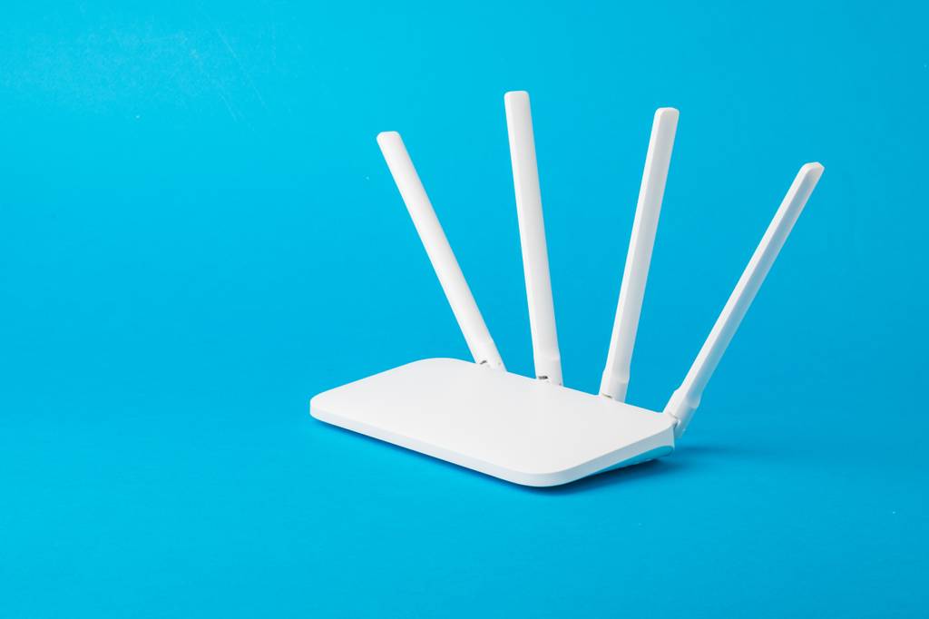 Ein Router mit vier Antennen vor blauem Hintergrund.