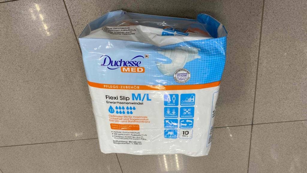 Eine Packung mit 10 Stück getesteten Duchesse-Windeln für Erwachsene liegt auf dem Boden.