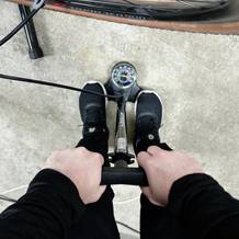 Eine Person pumpt mit der Dunlop 17049 einen Fahrradreifen auf. Die Anzeige der Standpumpe ist gut sichtbar und der Standfuß stabil positioniert.