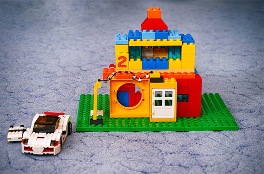 Duplo im Test: Ein Duplo Haus auf Platten sowie ein Auto aus Lego.