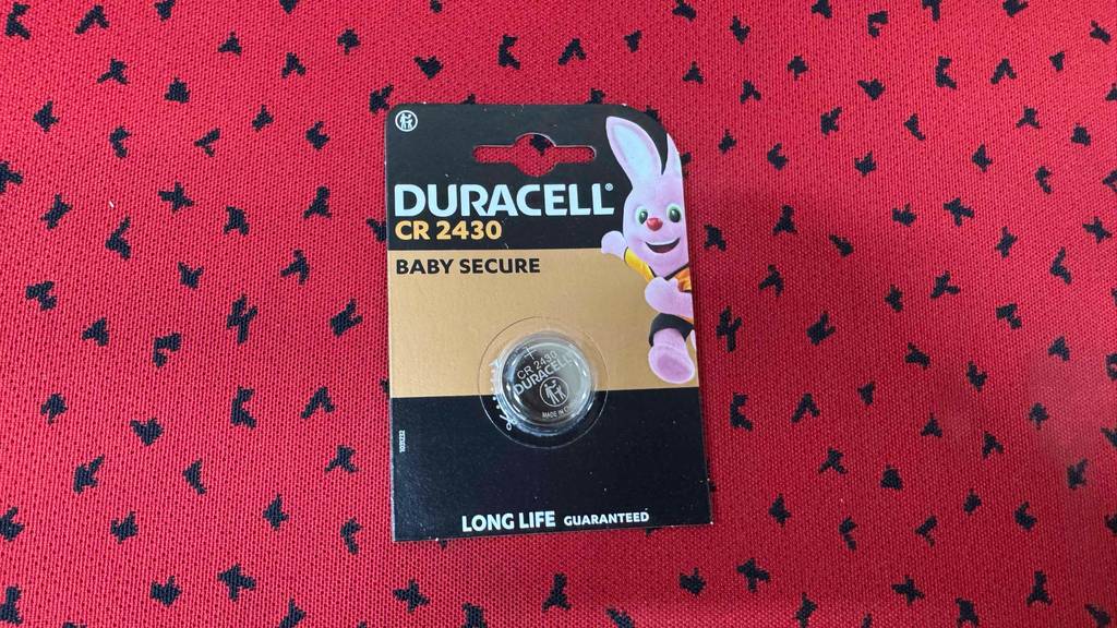 CR2430 Vergleich: Eine Packung mit einer getesteten CR2430 Knopfbatterie liegt auf einer roten Oberfläche.