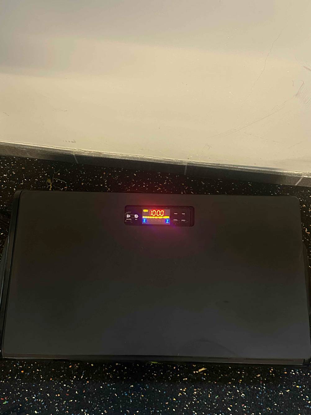 Ein Durchblutungs-Stimulator im Test auf einem dunklen Boden mit leuchtendem Display.