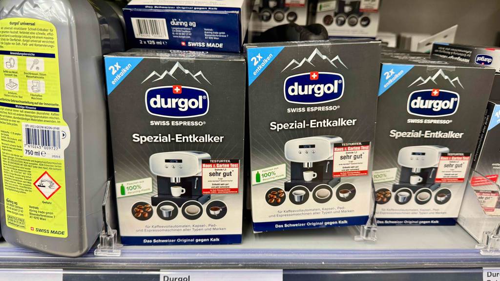 Getestet: Entkalker für Kaffeevollautomaten in der Packung mit zwei Entkalker-Flaschen stehen auf einem Verkaufsregal nebeneinander.