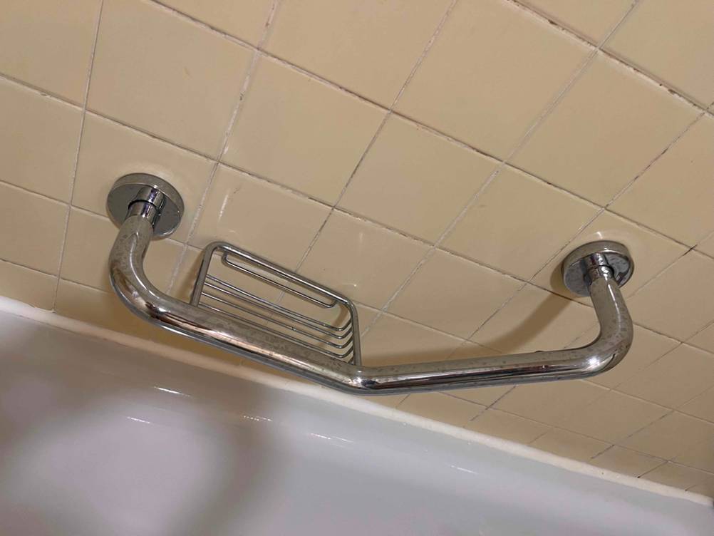 Unter der getesteten Duschablage mit Stange ist eine weiße Badewanne.