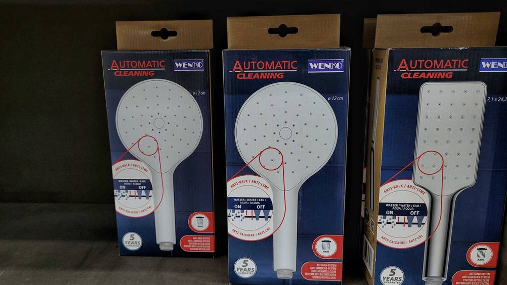 Getestet: Mehrere verpackte Duschköpfe nebeneinander in einem Regal.