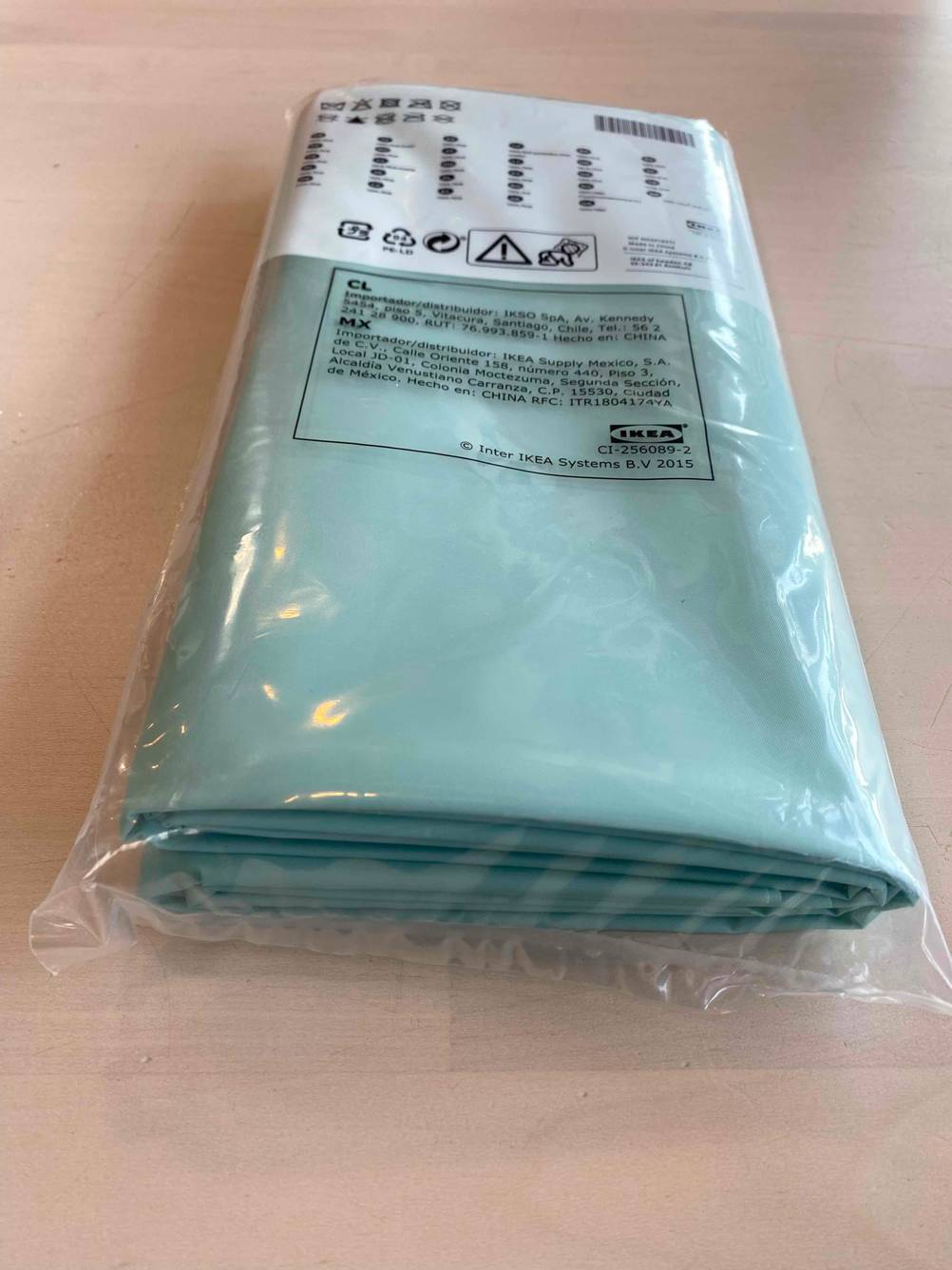 Ein verpackter Duschvorhang im Test von der Seite auf einer hellen Fläche.