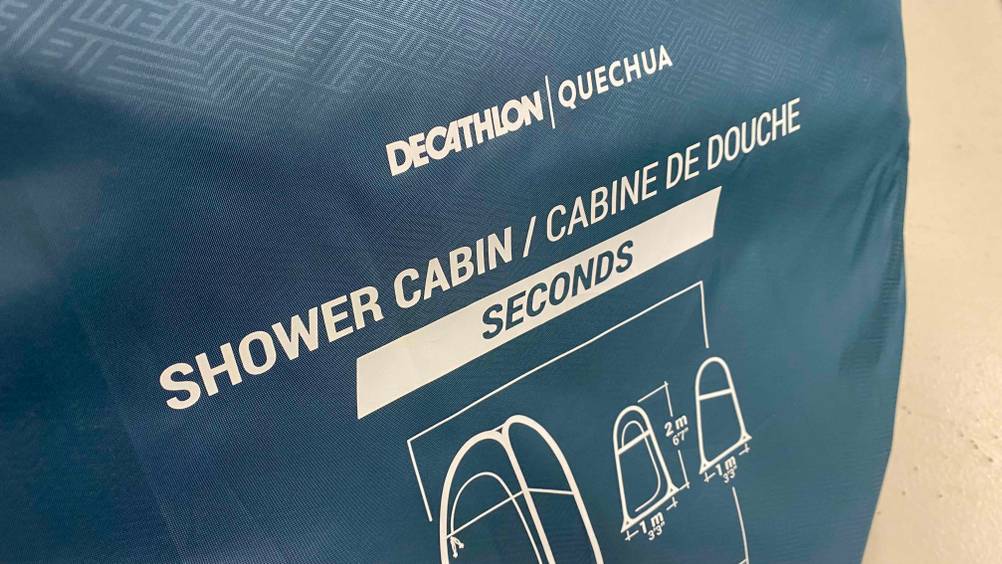 Schutzhülle des getesteten Duschzeltes von vorne mit Logo und Grafiken.