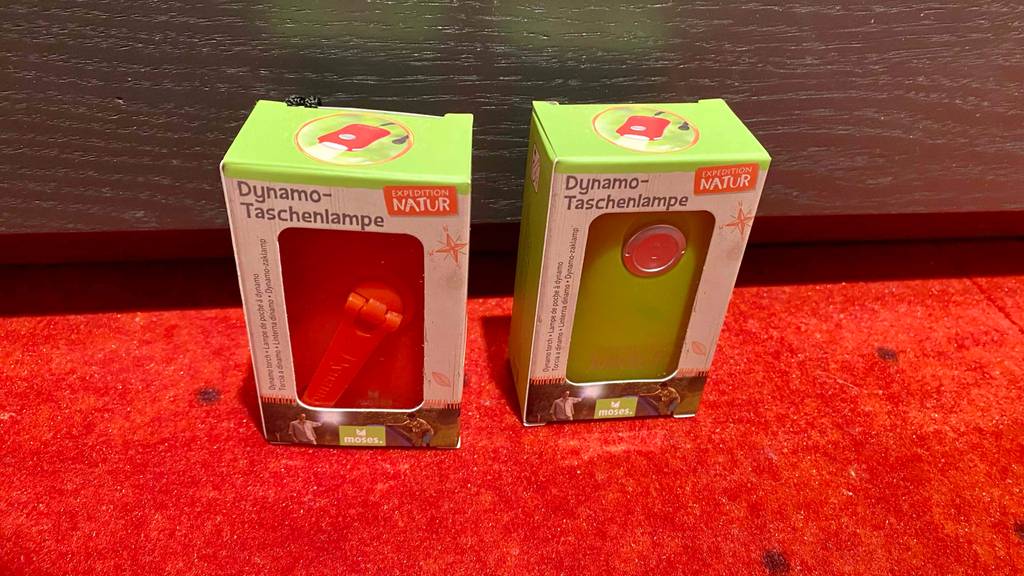 Zwei getestete Dynamo-Taschenlampen stehen auf dem Boden. 