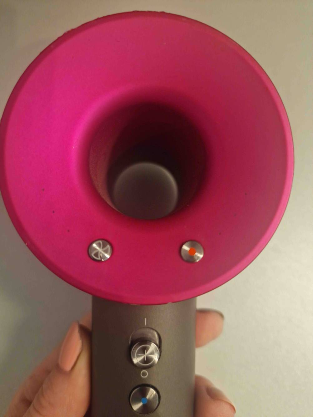 Im Test: Ein Haartrockner von hinten mit Bedienelementen von einer Hand gehalten.