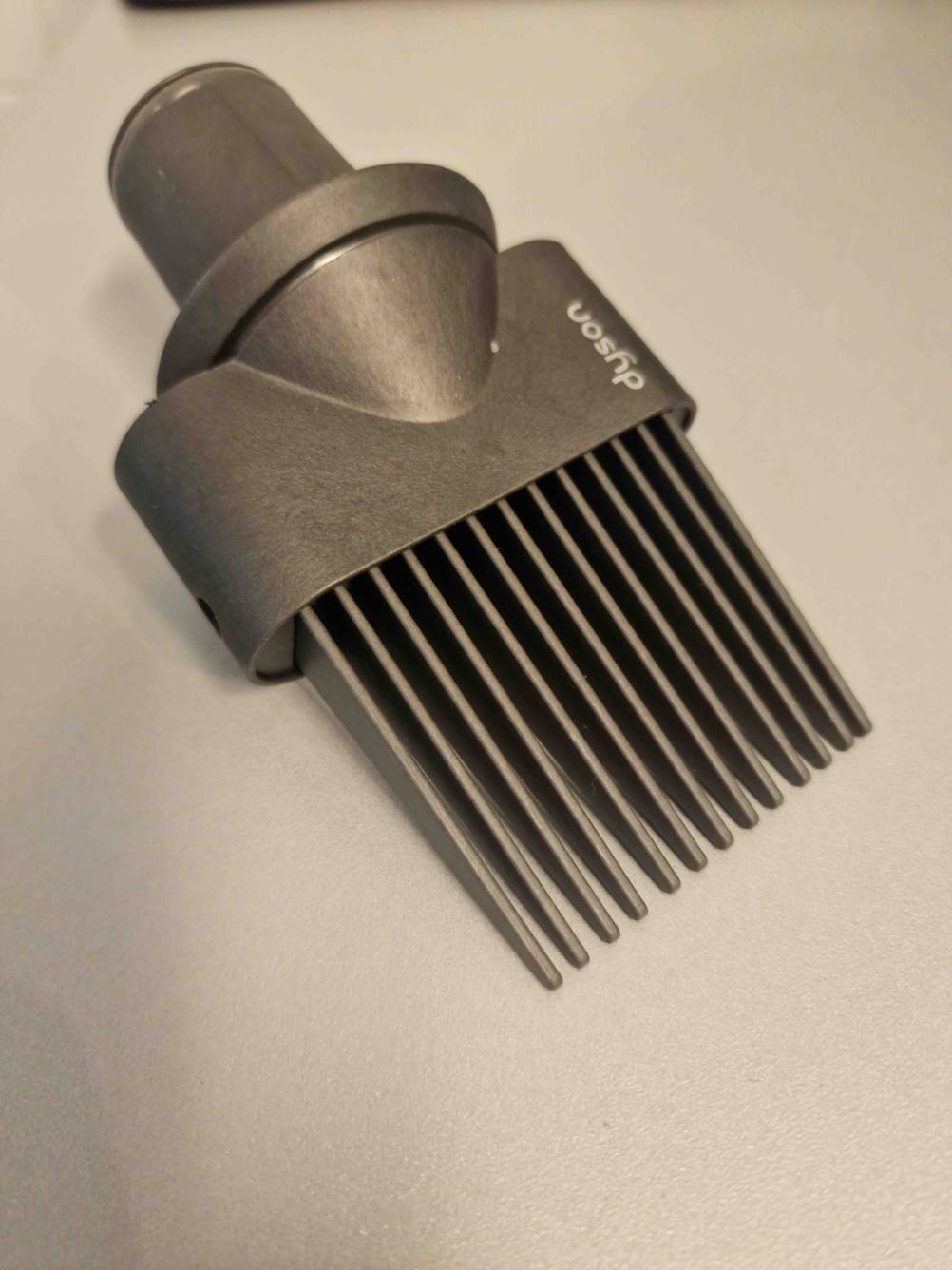 Nahaufnahme eines Aufsatzes eines getesteten Haartrockners auf einer hellen Fläche.