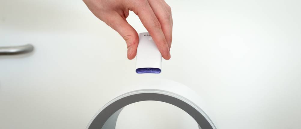 Eine Fernbedienung wird auf einem Dyson Turmventilator abgelegt.