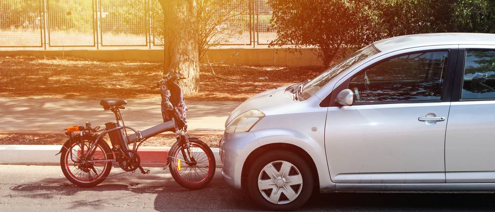 Eine E-Bike steht dicht vor einem Auto.