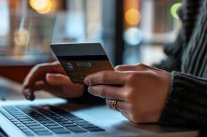 E-Commerce-Plattformen im Test: Eine Frau bezahlt am Laptop in einem Onlineshop mit der Kreditkarte.