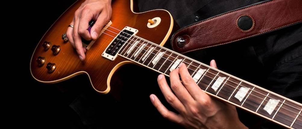 E-Gitarren-Saiten-Test: Ein Mann spielt auf einer E-Gitarre.
