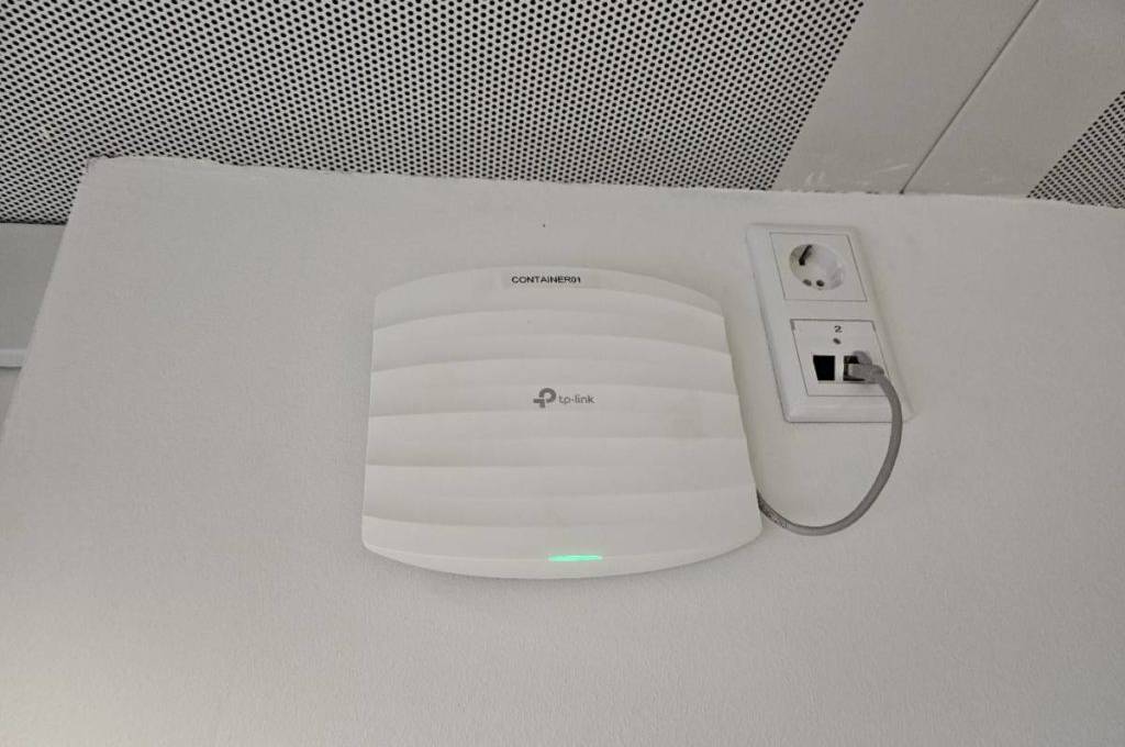 Der weiße Access Point im Test von Tp-Link steht angeschlossen auf einem weißen Untergrund.