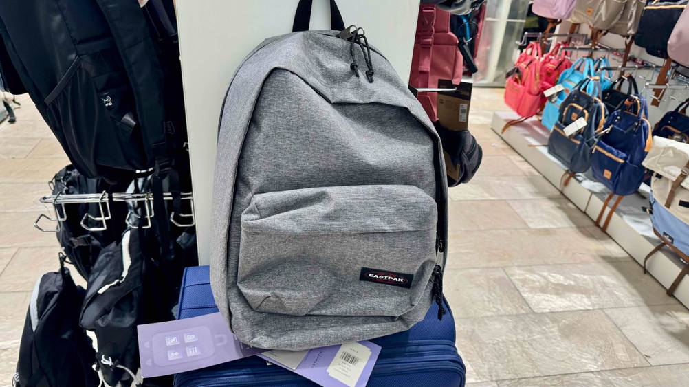 Auf einem blauen Koffer in einem Laden befindet sich der Eastpak-Rucksack im Test.