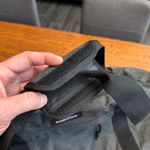 Eine Hand hält den Handgriff der Eastpak TERMINAL-+-Reisetasche fest