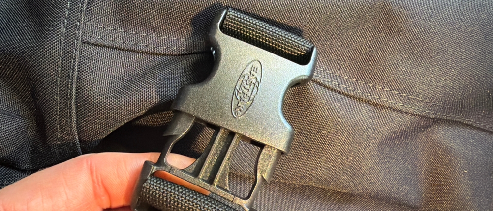 Eine Hand verschließt die Eastpak Tranverz.