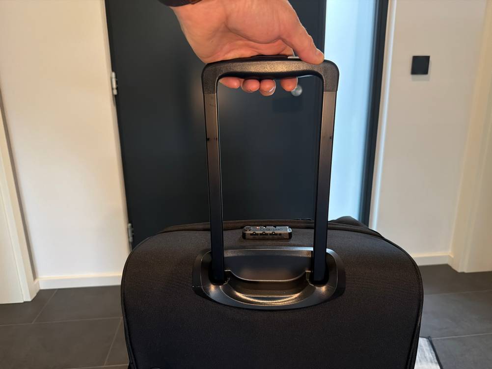 Eine Hand hält die Eastpak Tranverz am ausgefahrenen Griff fest.