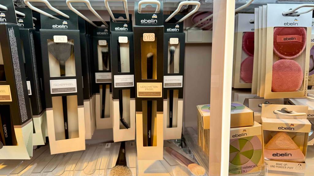 Lidschattenpinsel im Test. Mehrere Packungen hängen zwischen anderen Pinseln in einem Regal.