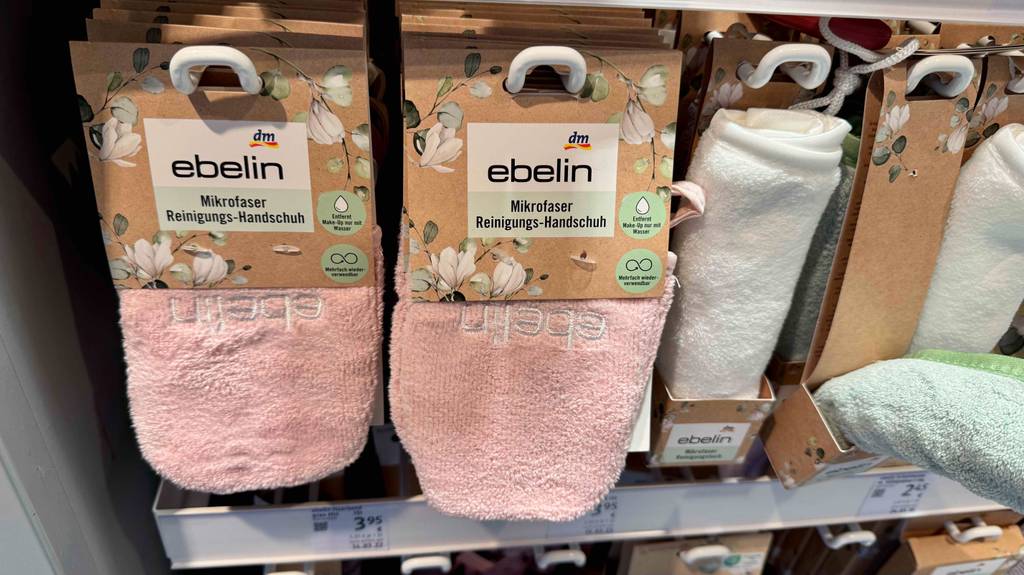 Im Test: Mehrere verpackte Mikrofaser-Handtücher hängen in einem Regal.