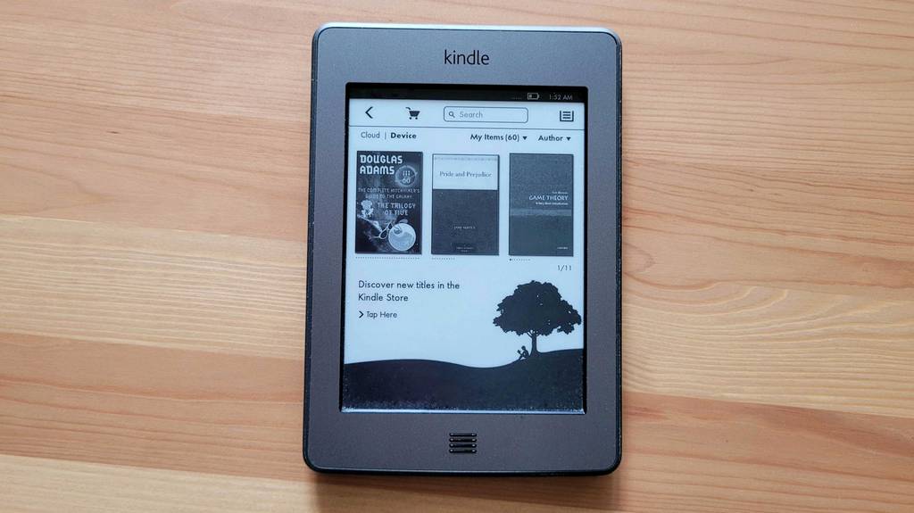 Ebook-Reader von der Marke Kindle auf einem Holztisch. 