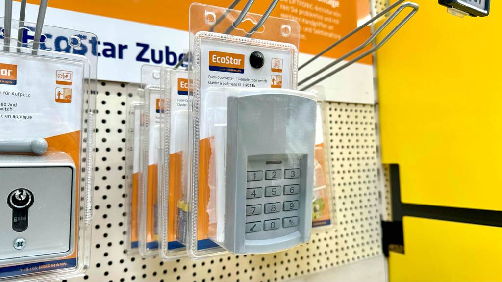 Codeschloss im Test: Mehrere originalverpackte Geräte hängen hintereinander in einem Lochregal.