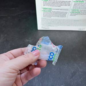 Eine Hand hält einen geöffneten Ecover-Classic-Spülmaschinentab fest.