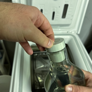 Der Plastikschutz der Verschlusskappe des Ecover-Waschmittels wird entfernt.