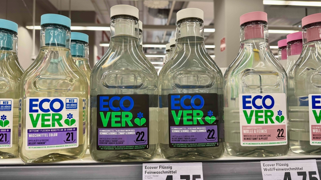 Waschmittel für schwarze Wäsche im Test: Mehrere Flaschen stehen zwischen anderen Waschmittelsorten in einem Regal.