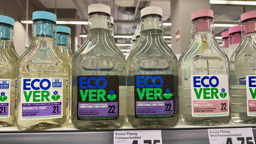 Waschmittel für schwarze Wäsche im Test: Mehrere Flaschen stehen zwischen anderen Waschmittelsorten in einem Regal.